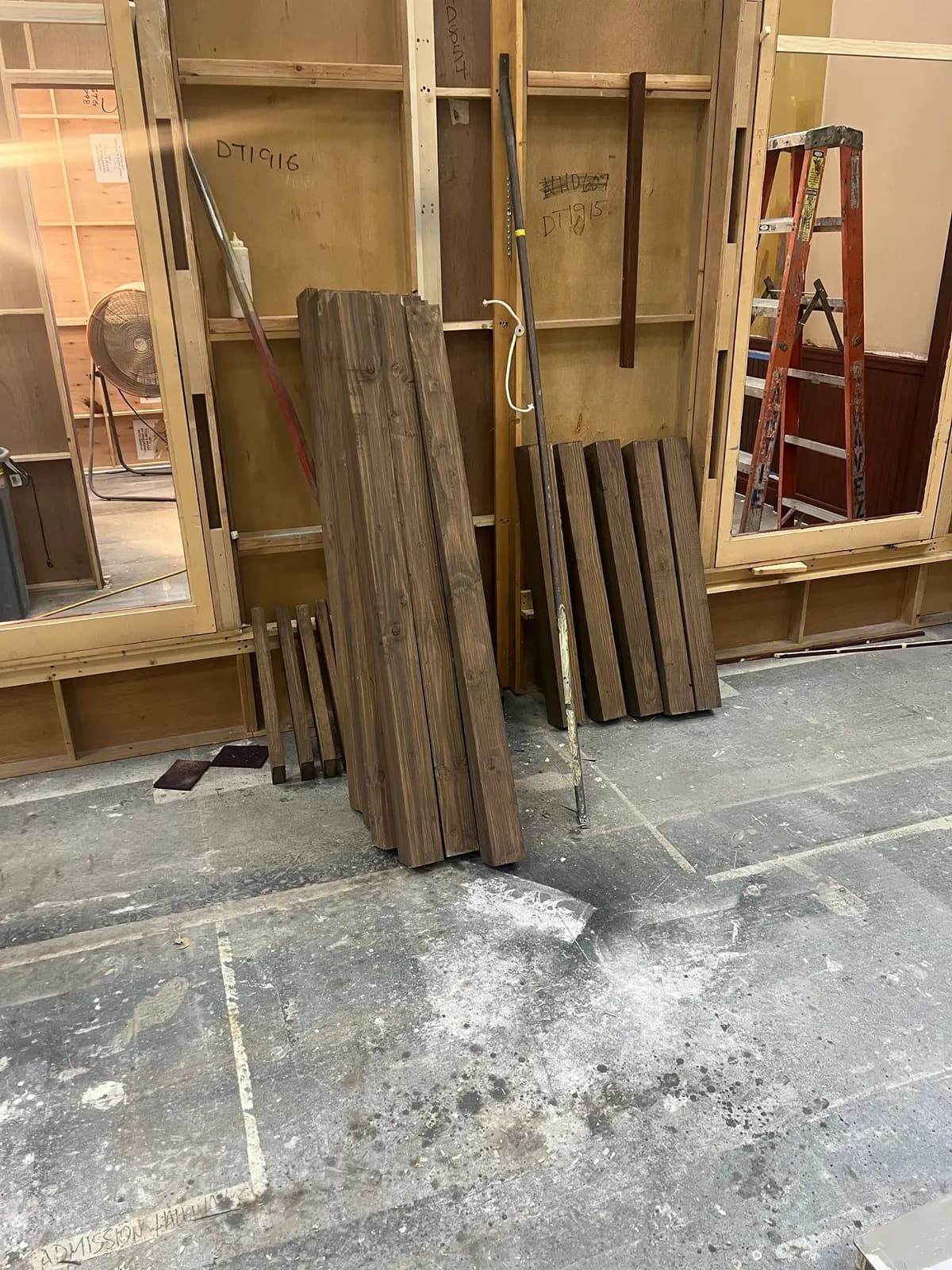 Stained bench legs leaning against a wall to dry