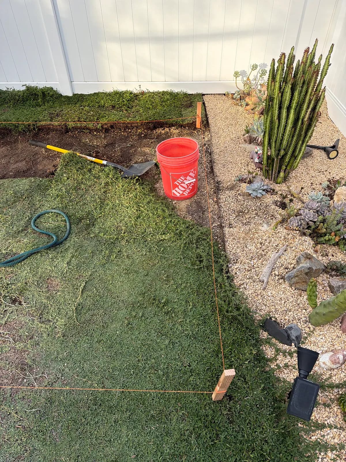 Close-up of a staked corner, with sod peeled back along the string line